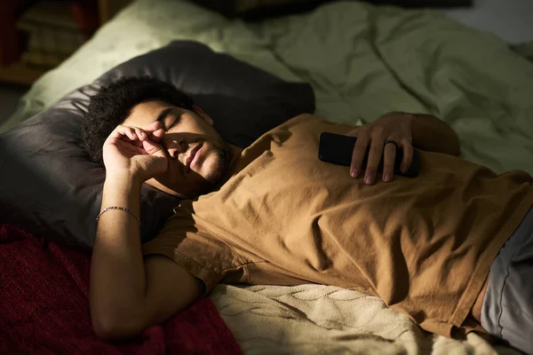 年轻疲惫的男人躺在床上睡在卧室里的高角镜 — 图库照片