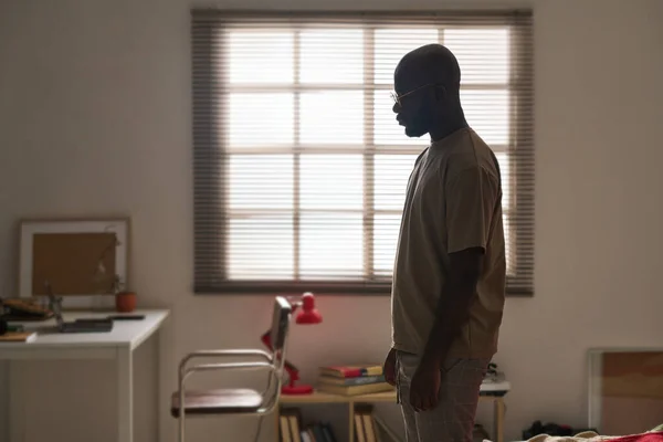 沮丧中的非裔美国人独自站在房间里 — 图库照片
