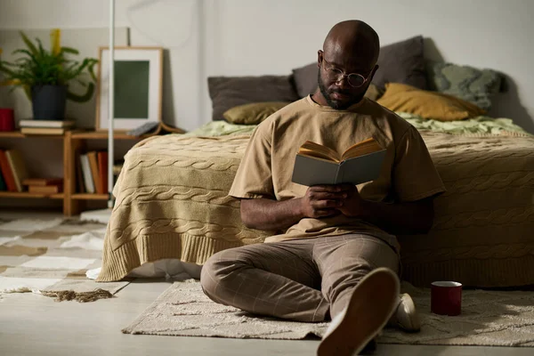 Afroamerikansk Man Sitter Golvet Med Bok Och Njuter Att Läsa — Stockfoto
