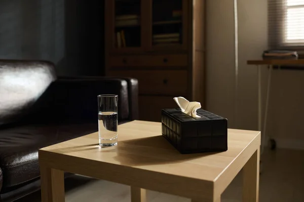 小木方桌 装有纯净水杯和黑匣子 内装为心理治疗人员病人准备的组织 — 图库照片