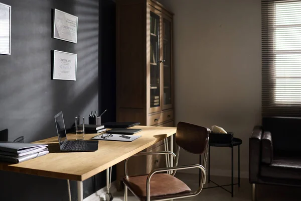ノートパソコン フォルダ 水のガラスと証明書とグレーの壁に立って机の上の他の供給と職場 — ストック写真