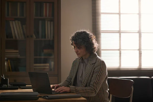 认真的女顾问坐在办公室工作时 一边在笔记本电脑键盘上打字 一边在网上咨询有问题的病人 — 图库照片