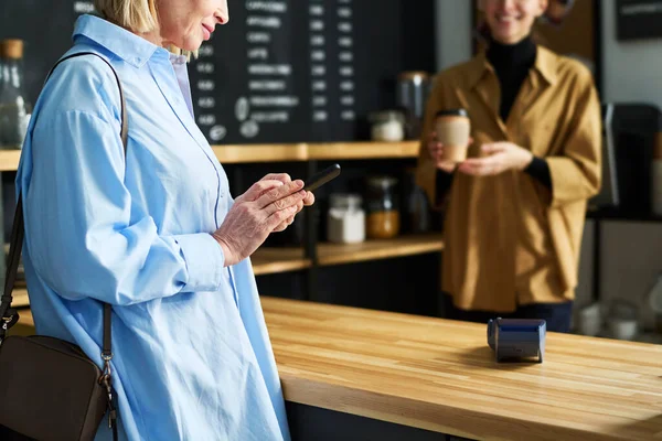 Зрелая Женщина Синей Рубашке Используя Смартфон Стоя Стойки Кафе Ожидая — стоковое фото