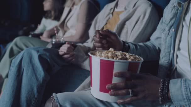 人们在电影院看电影的选择性焦点 吃爆米花的难以辨认的黑人 — 图库视频影像