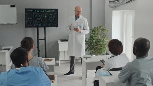 Długie Ujęcie Poważnego Dojrzałego Lekarza Białym Fartuchu Trzymającego Cyfrową Tabletkę — Wideo stockowe