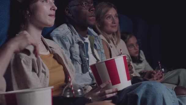 快乐的非裔美国男人和白人女人一起在电影院看电影 吃爆米花 喝可乐 — 图库视频影像
