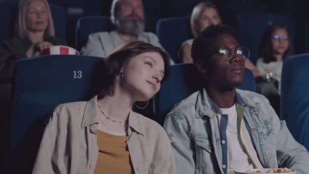 白人女孩在电影院看爱情片时依偎在黑人男朋友身边的慢动作 — 图库视频影像