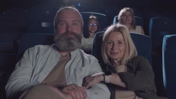 可爱成熟的白人男子和他的妻子坐在电影院大厅里 对着镜头微笑 慢镜头拍摄 — 图库视频影像
