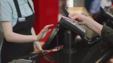Tanımlanamayan olgun bir kadın sinema bileti alıyor ve banka kartıyla ödüyor.