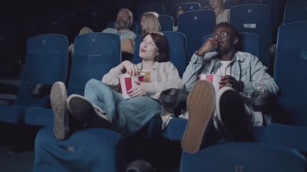 现代年轻的天才Z黑人男人和他的白人女朋友喜欢在电影院里看电影和吃爆米花 — 图库视频影像
