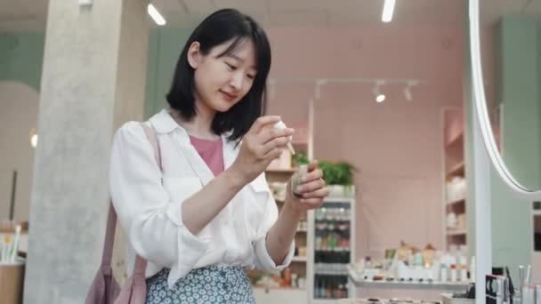 Junge Asiatin Lässt Einen Klecks Flüssiges Hautpflegeprodukt Auf Ihre Hand — Stockvideo