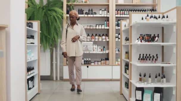 Junge Schwarze Frau Mit Einkaufskorb Läuft Auslagen Mit Schönheitspflegeprodukten Einem — Stockvideo