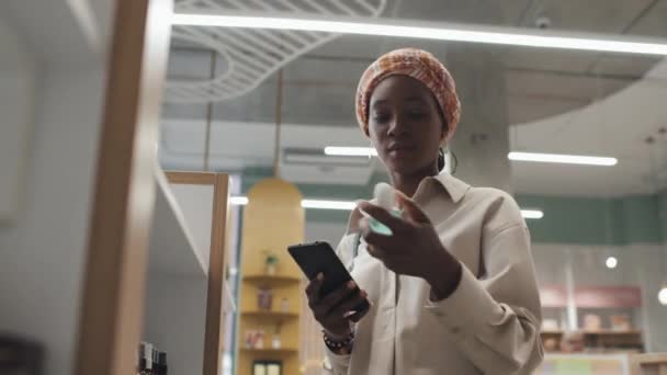 Junge Schwarze Frau Liest Online Informationen Über Neues Hautpflegeprodukt Handy — Stockvideo