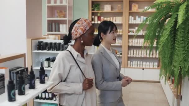 Genç Mağaza Asistanı Iki Kozmetik Ürünü Sergiden Alıp Karşılaştırırken Bunları — Stok video