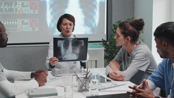 成熟的女医生与多族裔医科学生一起坐在桌旁 教她们如何使用X光摄影 — 图库视频影像