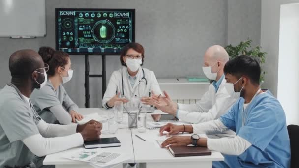 Etnicamente Diverso Grupo Médicos Vestindo Máscaras Assistir Reunião Sentado Mesa — Vídeo de Stock