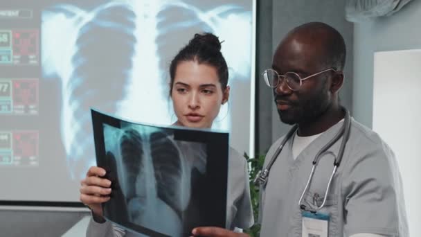 非裔美国人和白人实习生或持有X光照片进行诊断的医科学生 — 图库视频影像