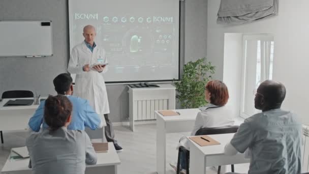 Nowoczesny Dojrzały Lekarz Kaukaski Trzymający Tabletki Cyfrowe Prezentujący Nową Technikę — Wideo stockowe