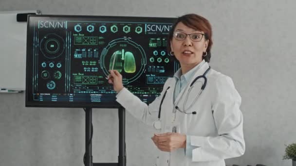 向医学专业学生或实习生授课的成熟女医生的中期画像 显示屏幕上的图表 — 图库视频影像