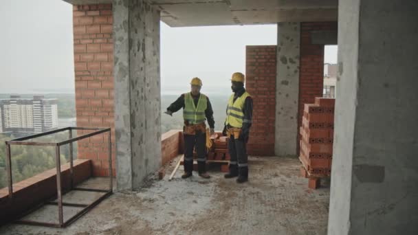 Длинный Снимок Этнически Разнообразных Мужчин Униформе Работающих Строящемся Многоэтажном Здании — стоковое видео