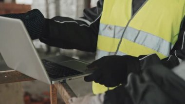 Dizüstü bilgisayardaki verileri kontrol eden tanınmayan inşaat işçilerinin orta bölüm seçici odağı