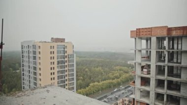 Sıkıcı bir günde çok katlı bina ve bina inşaatı ile şehir manzarasının yan görüntüsü