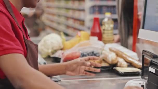 Кассирша Красной Униформе Сканирует Пищевые Продукты Обслуживая Клиентов Супермаркете — стоковое видео