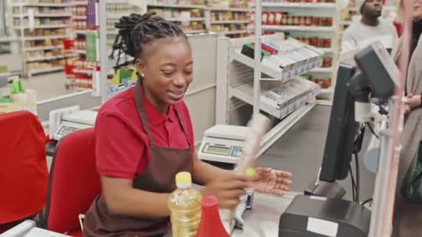 Junge Freundliche Afroamerikanische Kassiererin Lächelt Während Sie Kunden Bedient Die — Stockvideo