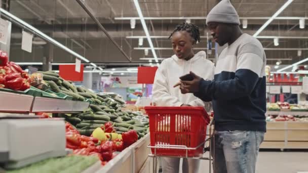 Jong Zwart Paar Kiezen Kopen Van Verse Groenten Bij Productie — Stockvideo