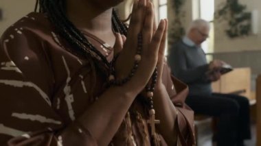 Afrika kökenli Amerikalı genç bir kadının Katolik kilisesinde Tanrı 'ya dua edişini yakından çek.