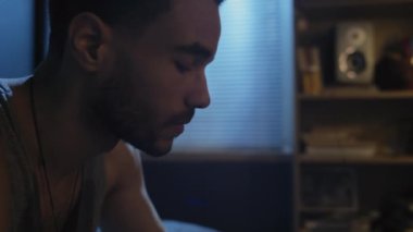 Yatak odasında depresyona giren genç siyahi adamın el kamerasıyla çekilmiş gece geç saatlerde viski içişi.