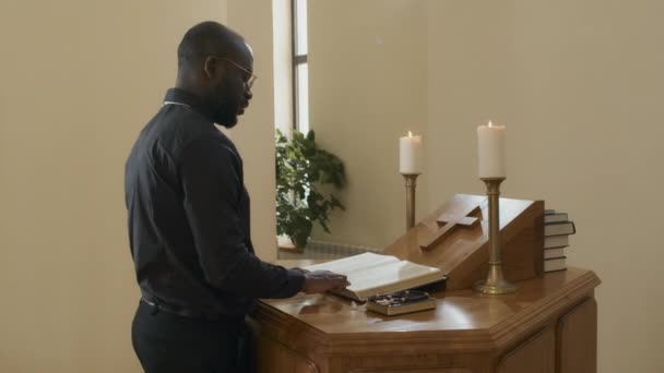 非洲裔美国牧师手持念珠站在天主教堂的圣坛前 向上帝祈祷 — 图库视频影像