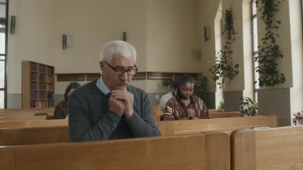 Ältester Gläubiger Mensch Sitzt Auf Bank Katholischer Kirche Und Betet — Stockvideo