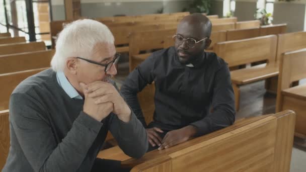 Junge Erwachsene Afroamerikanische Katholische Priester Hören Dem Älteren Kaukasischen Gemeindemitglied — Stockvideo