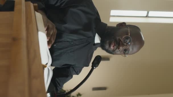 年轻的黑人牧师站在木制讲台上 手持话筒 上面有 宣扬布道 — 图库视频影像