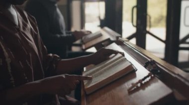 Katolik kilisesinde dua kitabı okuyan tanınmayan genç siyahi kadın cemaatin seçici odağı.