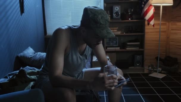 Νεαρός Στρατιώτης Καπέλο Που Καθόταν Στο Κρεβάτι Βράδυ Κρατώντας Ένα — Αρχείο Βίντεο