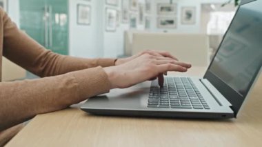İş yerinde oturan ve bilgisayarının klavyesine yazı yazan tanınmamış genç iş adamının yakın çekimi. Ofiste online çalışıyor.