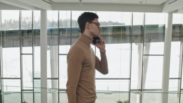 Young Manager Using His Mobile Phone Talk His Colleague While — Stock Video