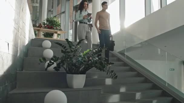 동료들 현대식 사무실에서 계단을 내려가며 일하는 시간에 이야기하는 보인다 — 비디오