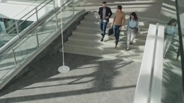 İşten sonra merdivenlerden inerken birbirleriyle konuşan bir grup meslektaşın yüksek açılı görüntüsü.