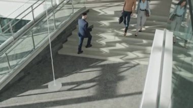 Ofis binasının koridorunda yürüyen iş adamlarının yüksek açılı görüntüsü