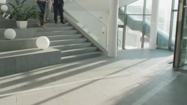 İş gününden sonra merdivenlerden inerken birbirleriyle konuşan bir grup iş adamı.