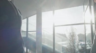 İş ortaklarının yakınlaşması anlaşma yapmak için el sıkışırken ofis koridorunda güneş ışığının arka planına karşı durmak...