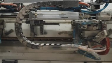 Mobilya fabrikasında çalışan otomatik kenar bantlama makinesinin yakın çekim görüntüsü.