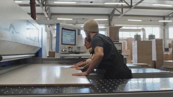 Trabajadora Fábrica Colocando Tablero Madera Máquina Con Ayuda Colega Masculino — Vídeos de Stock