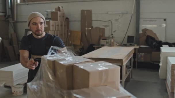 Άνδρας Εργαζόμενος Που Σπρώχνει Καλάθι Φορτωμένο Κουτιά Από Χαρτόνι Κατά — Αρχείο Βίντεο