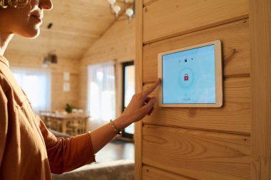 Yükleme, yeniden yükleme veya değiştirme işlemleri sırasında ekranda kilit işareti olan alarm sistemindeki genç kadının eli