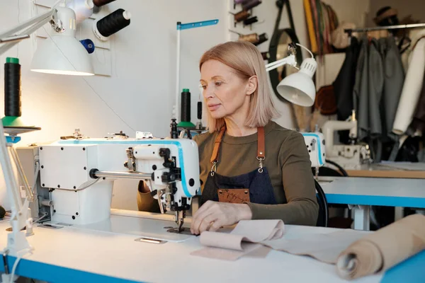 Зрелая Блондинка Швея Сидит Электрической Швейной Машинкой Время Работы Над — стоковое фото