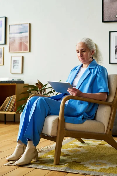 Empresária Madura Com Cabelos Longos Cinzentos Usando Tablet Enquanto Senta — Fotografia de Stock